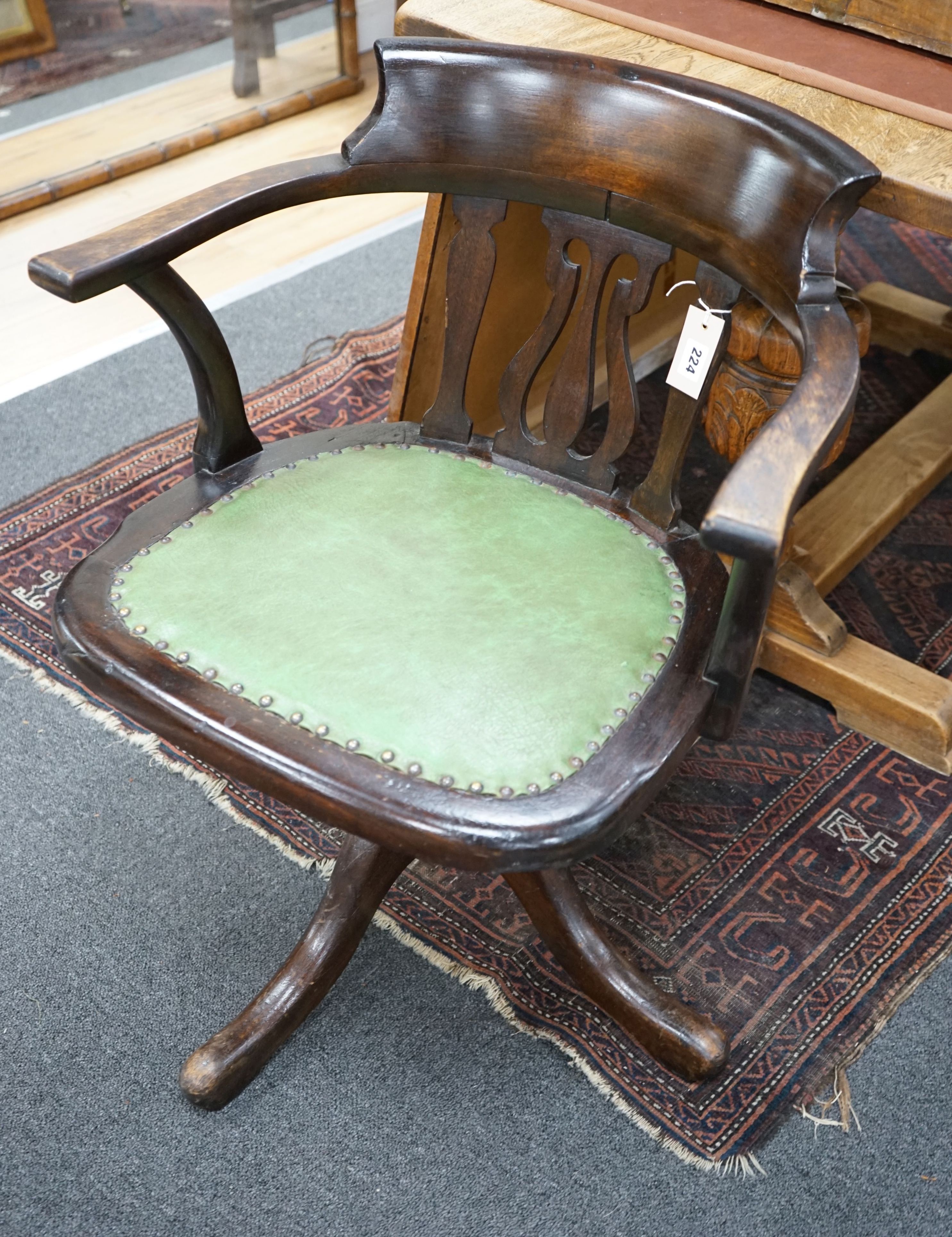 An Edwardian beech revolving office elbow chair